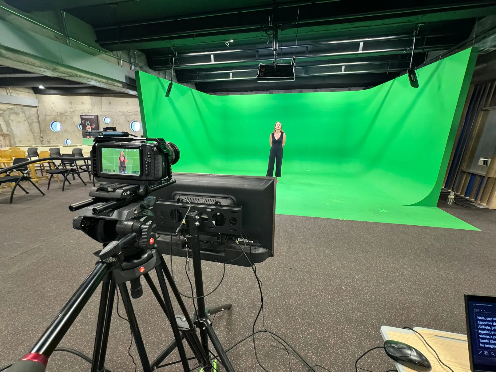 El croma del laboratorio visto desde la cámara de cine en primer plano: una persona de pie sobre el fondo verde infinito.
